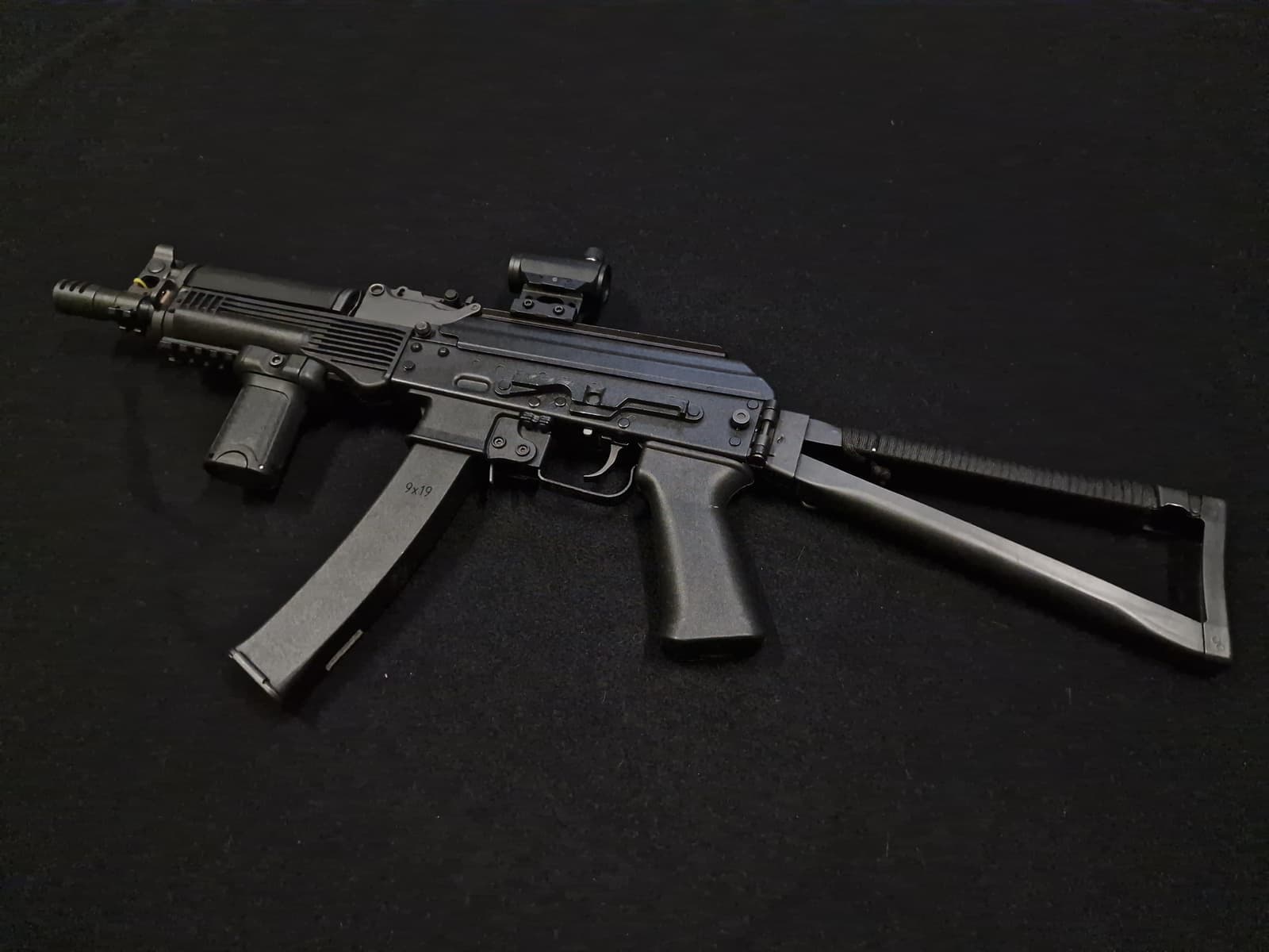 Réplique AEG 9x19 vue de profil avec crosse pliante dépliée et poignée avant